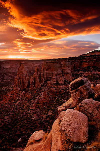 A fiery sunrise cloud over kissing couple formation is prelude to an autumn storm. Colorado National Monument, CO