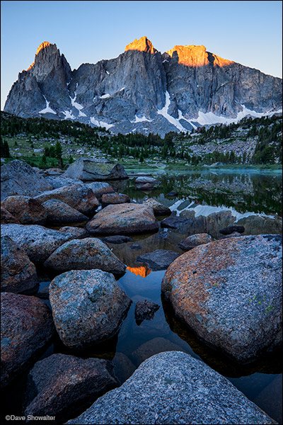Sunrise grazes Warbonnet and Warrior Peaks reflected in Lonesome Lake. The Cirque Of The Towers is a world-renowned climbing...
