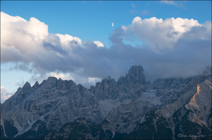 Clouds part just before sunset to reveal a moon over Piz Popena in the Cristallo Gruppe. Dolomite Alps, Italy