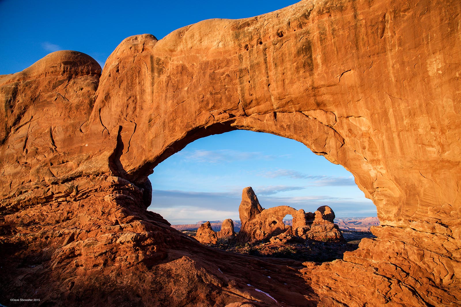 Sunrise paints North Window and Turret Arch in gold one spring morning. Arches National Park in home to the highest concentration...