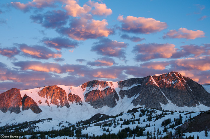 &nbsp;Puffy pink clouds drift over the Snowy Range high peaks as first light grazes the ridge tops.