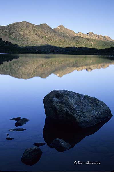 Unnamed peaks are reflected in appropriately named Treasure Vault Lake just after sunrise.&nbsp;