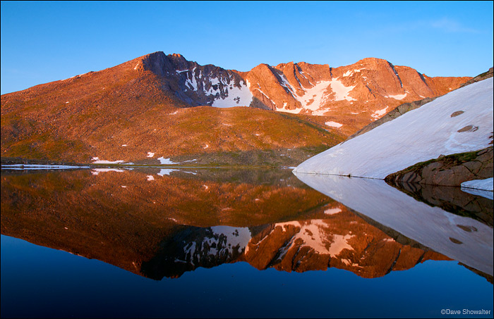 Mount Evans, 14,264' and one of Colorado's 54 "Fourteeners" is reflected in Summit Lake, just after sunrise. Early July is a...