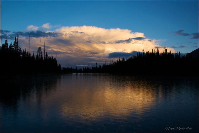 A sunset storm cloud passes as another drops summer snow on Hooper Lake. The droplets are pea-sized gropple snow in mid-August...