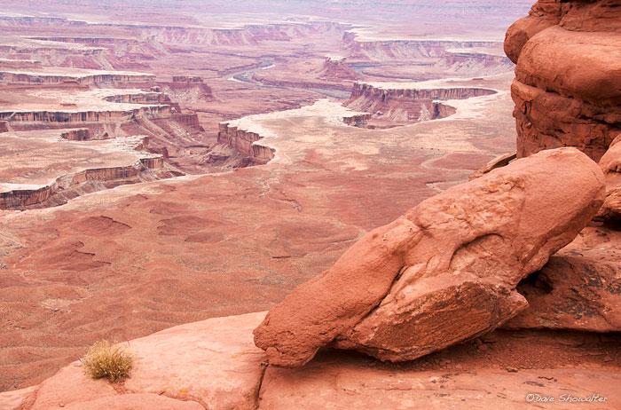 Blocks of Sandstone perched on the edge of Island In The Sky provide the foreground for this view of the Green River and the...