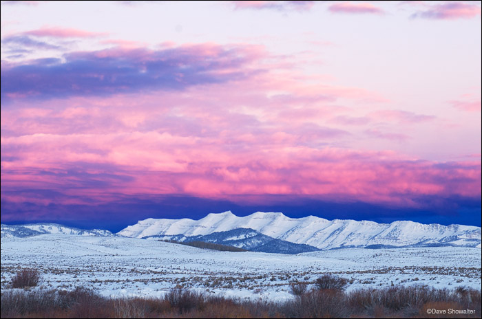 Tosi Peak, 11,380' below a colorful winter sunrise. The Gros Ventre Range is one of three mountain ranges that surround the Upper...