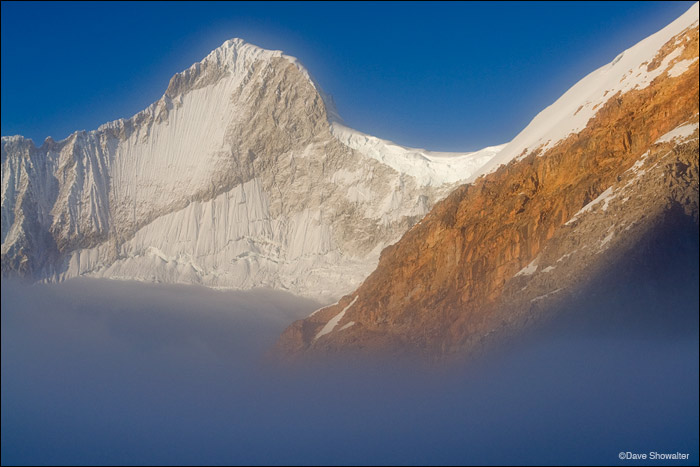 Huandoy, 6,354 meters in early morning light as fog rises from the valley below. Huandoy is virtually unclimable because of extreme...