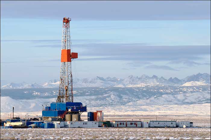 A drilling rig on the Pinedale Anticline is backed by the jagged peaks of the Wind River Range. Natural gas drilling on the the...