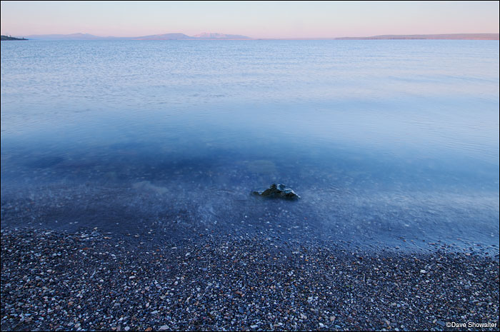 &nbsp;Sunlight turns distant Mount Sheridan shades of pink at dawn on Yellowstone lake.&nbsp;