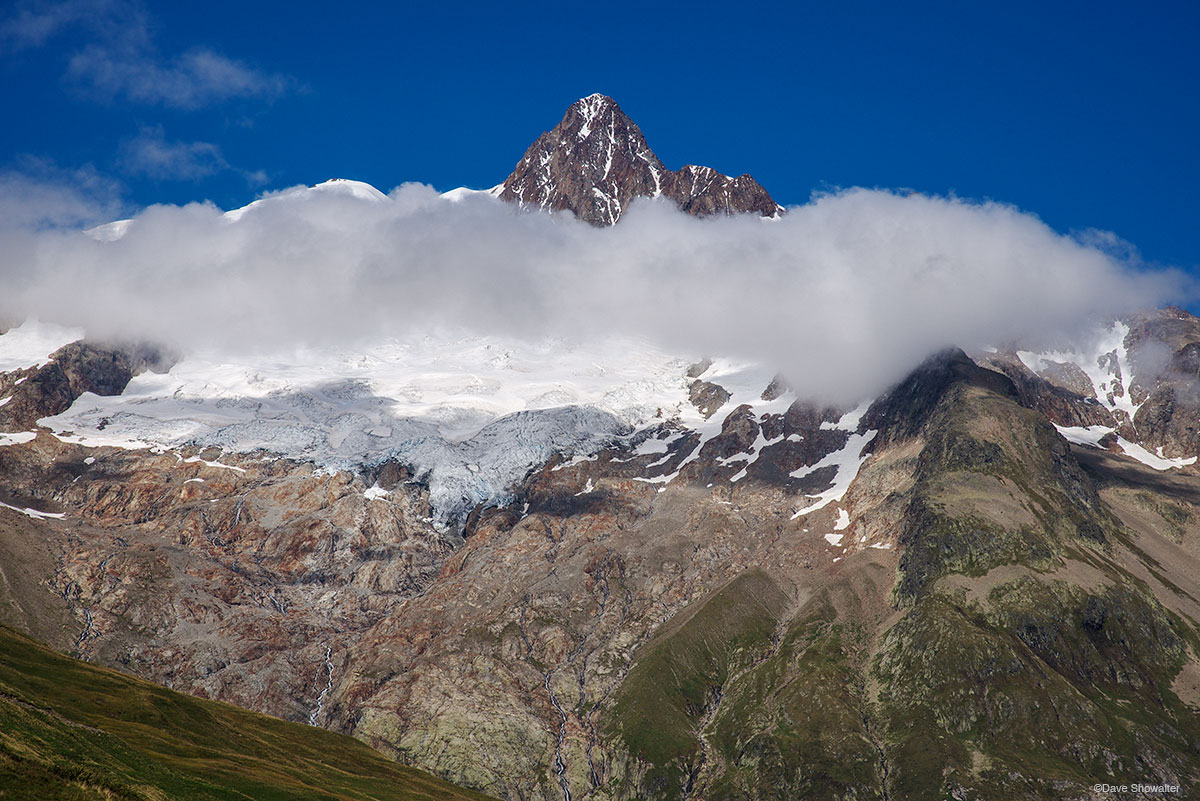 Below the Col De Seigne, Aiguille Des Glaciers is encircled by building clouds. Each afternoon on the Tour Du Mont Blanc these...