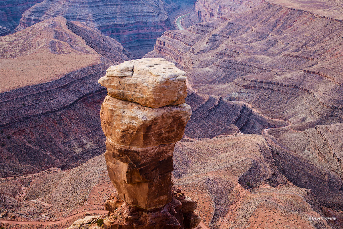 A towering sandstone column, separated from Cedar Mesa&nbsp;watches over the Goosenecks of the San Juan River from Muley Point...