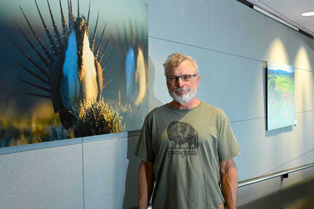 Dave Showalter next to his "Greater Sage-grouse Display" image at the Colorado: Sage Spirit and Roaring Rivers exhibit, sponsored...