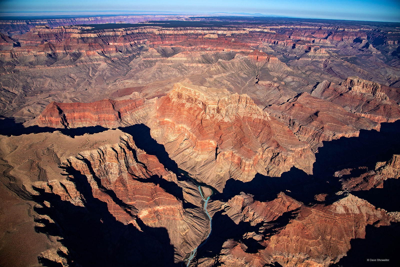 The thin aqua line of the Little Colorado River flows to the main stem of the Colorado River in shadow. The Little Colorado's...