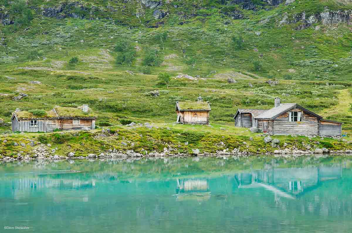 &nbsp;Rustic cabins are reflected in the turquoise waters of Gjende, a large glacier-fed lake in Jotunheimen. These aren't troll...