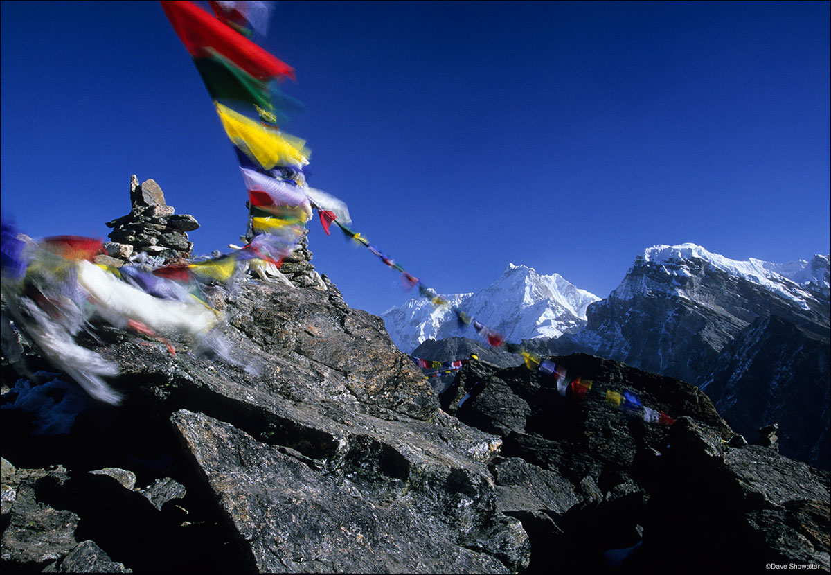 With a backdrop of Himalayan peaks, prayer flags catch the wind - they are placed in high places by Sherpas so their prayers...