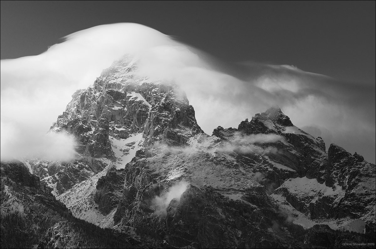 &nbsp;An autumn mountain wave cloud curls over the rugged Grand Teton and Teewinot Mountain at right. The Grand Teton stands...