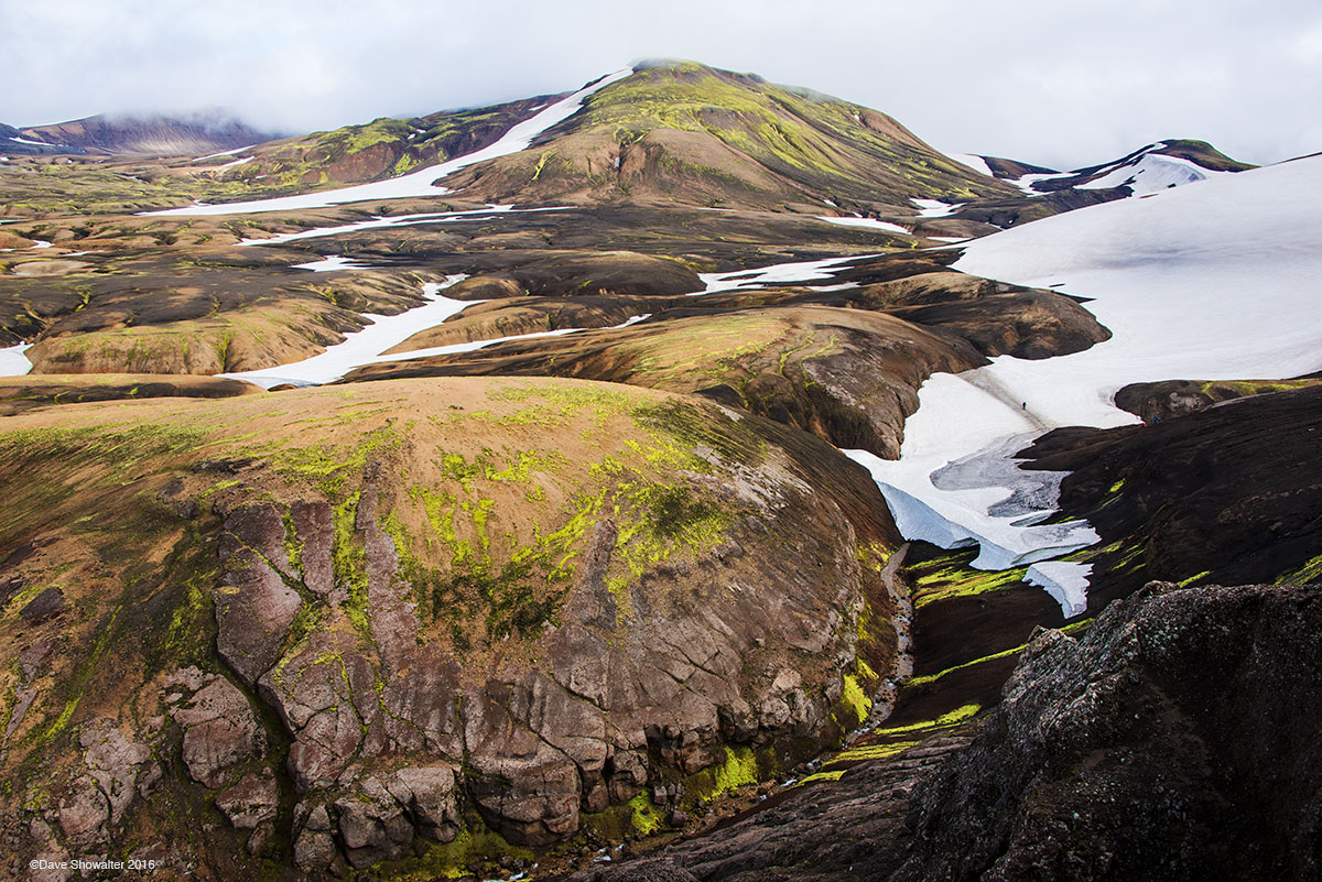 Low clouds lift to reveal a contrast of lava field and glacier on the second day of the Laugevegur trek. The glacier wraps Herfsdinger...