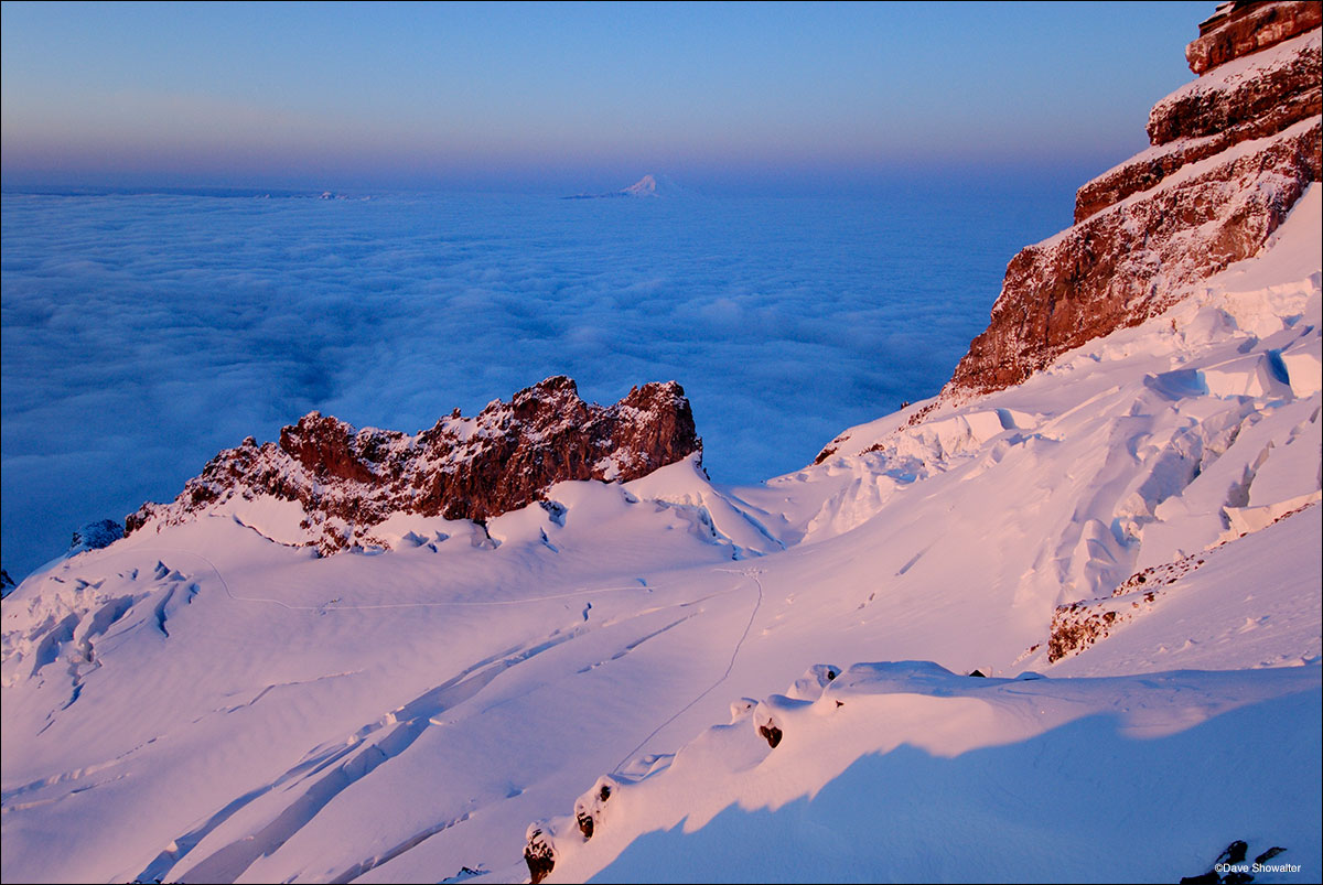 The Ingraham Glacier and a distant Mount Adams absorb the first rays of sunlight from Disappointment Cleaver on Mount Rainier...