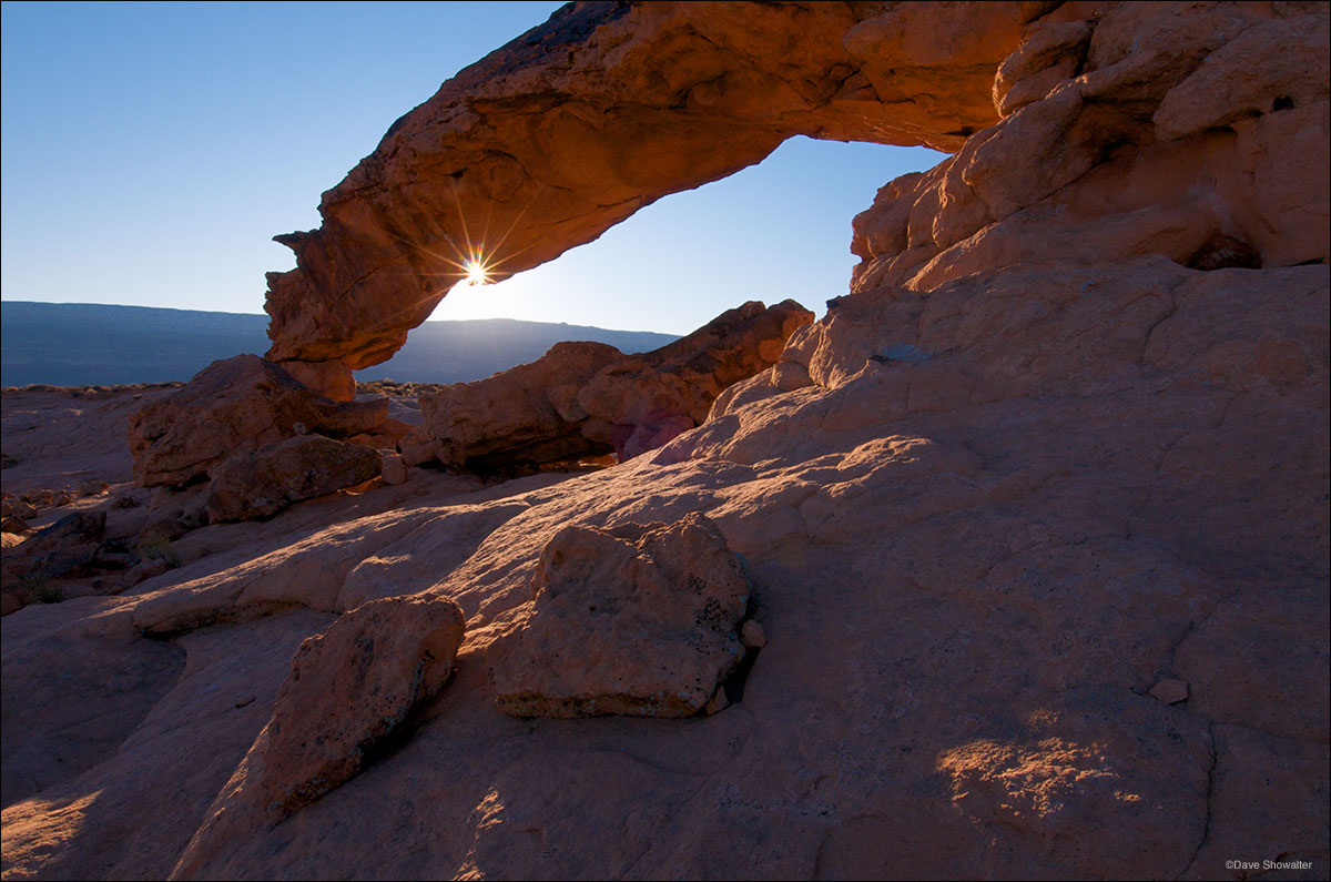 The setting sun creates a sun star in a notch of Sunset Arch. The arch is aptly named because it faces west and catches golden...